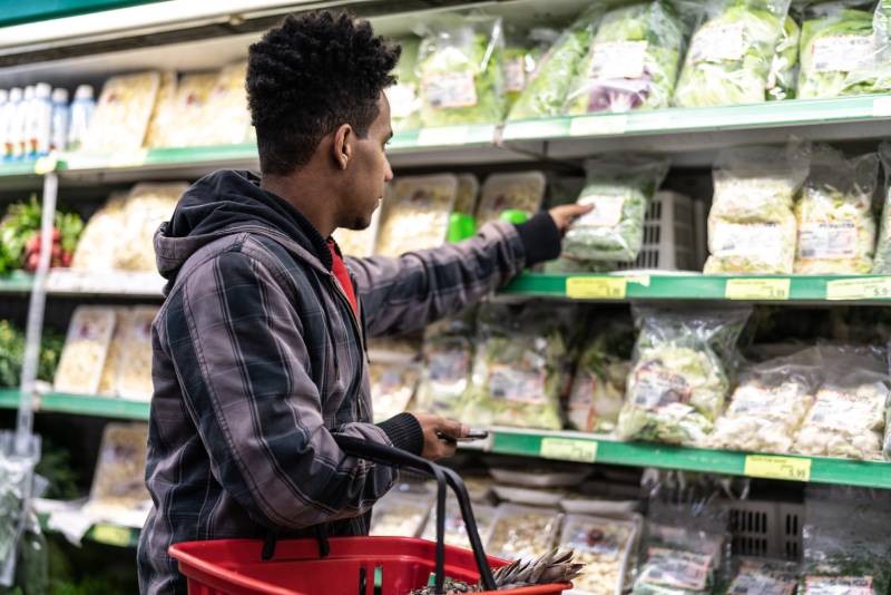 image of a man shopping for salad in the grocery store