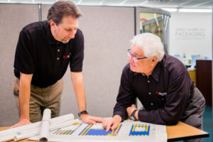 two great american packaging employees looking over product specifications