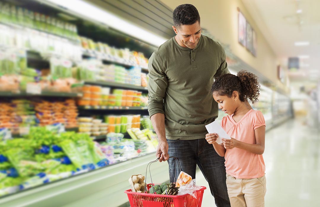 man shopping in the grocery store with his daughter