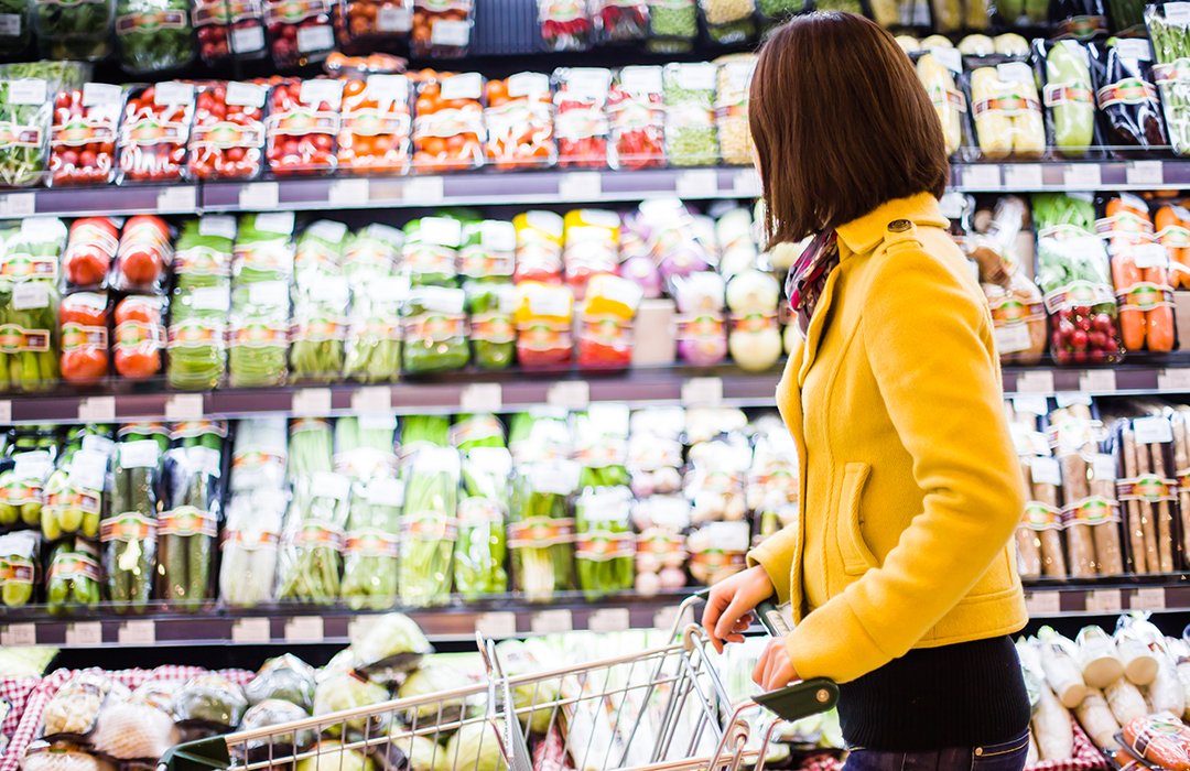 woman shopping for produce in plant based packaging