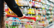 image of a person pushing a shopping cart in the grocery store